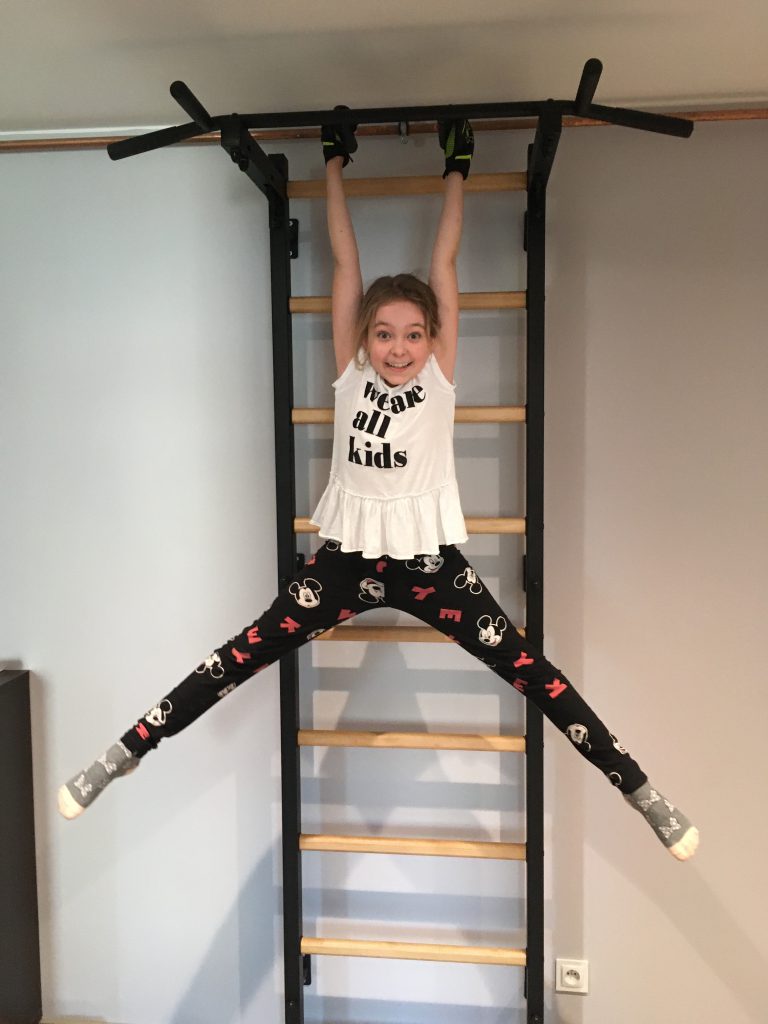 dziecko na zajęciach sportowych na drabince gimnastycznej